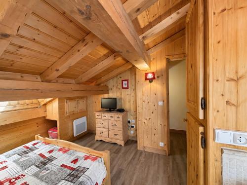 a bedroom with a bed in a wooden cabin at Le Tyrol in La Plagne Tarentaise