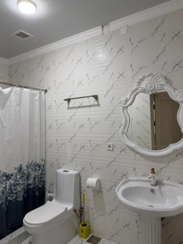 a bathroom with a sink and a toilet and a mirror at Nogai Karavan in Türkistan