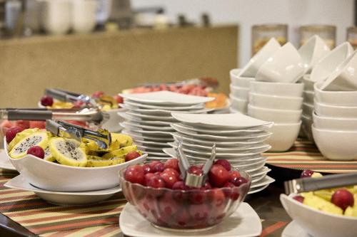 a table topped with plates and bowls of fruit at Hotel bh Parque 93 in Bogotá