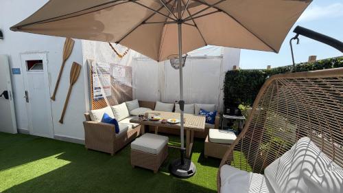 a patio with a table and an umbrella at Marevita Hostel in Alicante