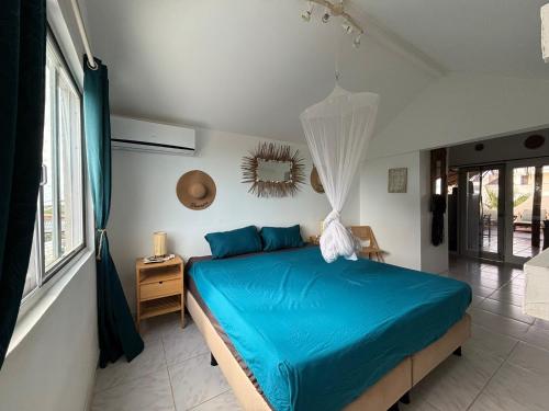 a bedroom with a blue bed in a room at BnBBonaire near the ocean in Kralendijk