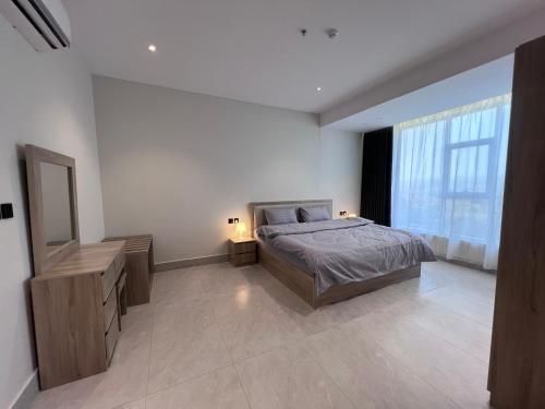 a bedroom with a bed and a large window at الباحه للشقق المخدومه in Al Baha