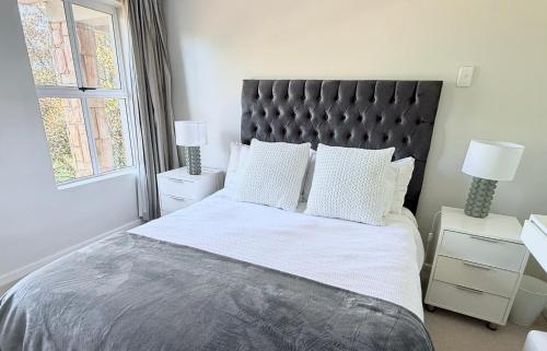 a bedroom with a large bed with white sheets and pillows at Beautiful 3 bedroom flat in Grahamstown