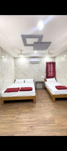 a room with two beds in a room at Arul Rayara Residency in Mādhavaram