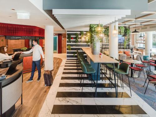 a man standing at a bar in a restaurant at Ibis Styles Wien City in Vienna