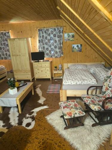 a bedroom with a bed and furniture in a attic at Chata Sandra in Revúca