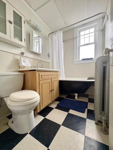 a bathroom with a toilet and a sink and a tub at The Elizabeth Suite B2 in Hartford