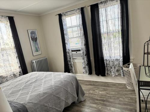 a bedroom with a bed and two windows at The Elizabeth Suite B2 in Hartford