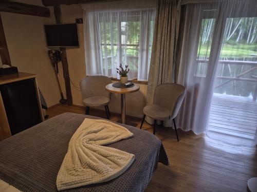 a bedroom with a bed and a table and windows at Kütioru saunamajad in Koloreino