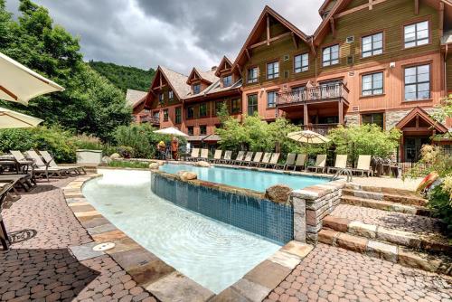 a house with a swimming pool in front of a house at Tremblant Prestige - Étoile 1520-2 in Mont-Tremblant