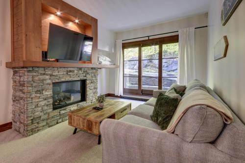 a living room with a couch and a fireplace at Tremblant Prestige - Étoile 1520-2 in Mont-Tremblant