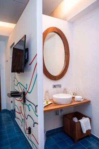 ein Badezimmer mit Waschbecken und Spiegel in der Unterkunft Del Carmen Concept Hotel Boutique by Chai in Guadalajara