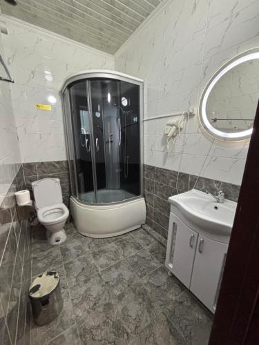 a bathroom with a shower and a toilet and a sink at MIR Hotel in Türkistan