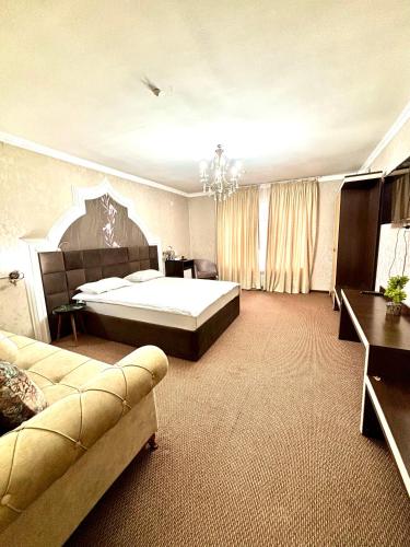 a large bedroom with a bed and a couch at MIR Hotel in Türkistan
