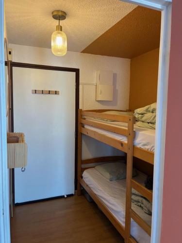 a room with two bunk beds and a door at Studio centre ville - 5min de la plage in Neufchâtel-Hardelot