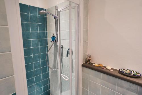 a shower in a bathroom with blue tiles at Bianca B&B in Florence