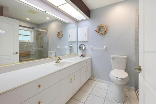 a white bathroom with a toilet and a sink at Palm Tree Parasdise in Englewood