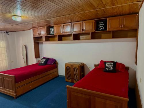 a bedroom with two beds and wooden cabinets at Los Horneros in Santa María