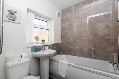 a bathroom with a sink and a toilet and a bath tub at 3 Bedroom House In Jarrow, Sleeps 6, Near Port of Tyne & Free Parking in Jarrow