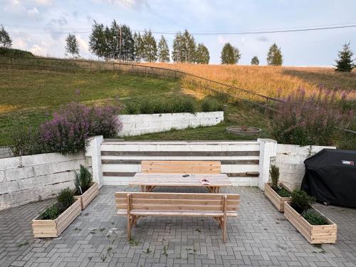 a wooden table and bench in front of a field at Chalupa Lázeňka in Pernink