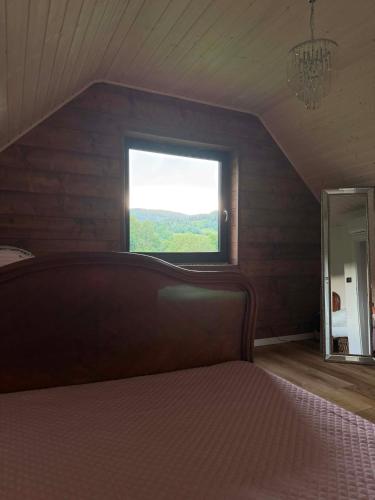 a bedroom with a large bed and a window at Karkonosze pod gwiazdami in Jarkowice