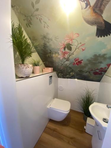 a bathroom with a toilet and a painting on the wall at Karkonosze pod gwiazdami in Jarkowice