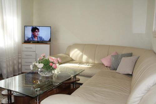 un soggiorno con divano e tavolo con TV di Ferienwohnung Sonnenhaft a Baden-Baden