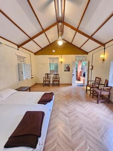 a bedroom with a bed and chairs in a room at K Bhoomi Joy by Earth in Bhīra Camp