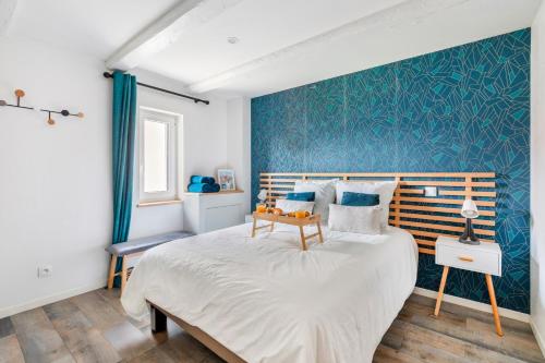 a bedroom with a bed and a blue wall at Le Bartholdi in Andolsheim