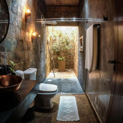 a bathroom with a toilet and a sink and a doorway at Hotel Pousada Rancho das Dunas in Santo Amaro