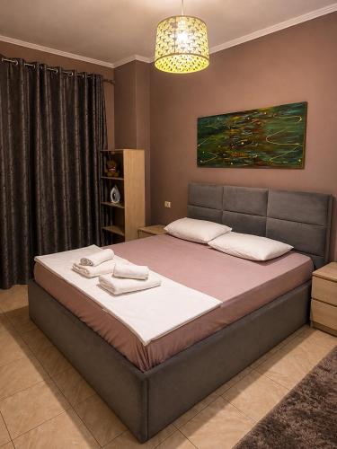 a bedroom with a large bed in a room at SiMar Apartment Tirana in Kashari