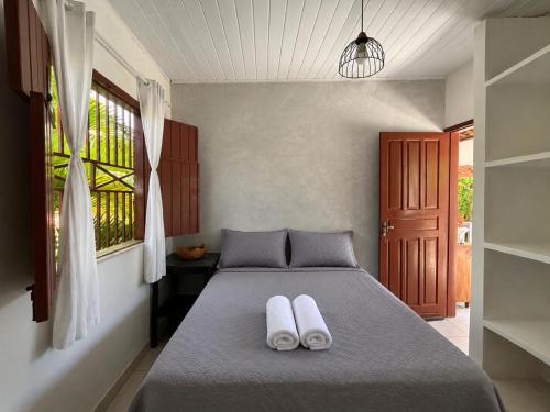 a bedroom with a bed with two white towels on it at Casa Luna in Marau