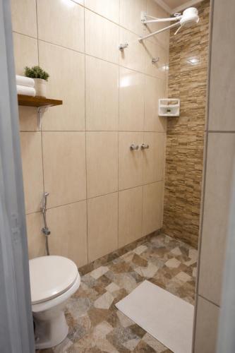 a bathroom with a toilet and a shower at Aconchego Caminho das Cachoeiras in Rio Acima