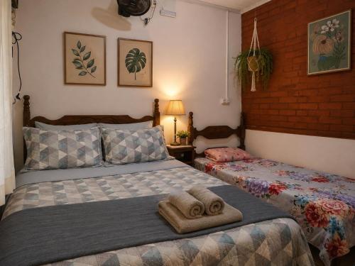 a bedroom with two towels sitting on a bed at Aconchego Caminho das Cachoeiras in Rio Acima