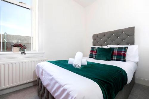 a bedroom with a large bed with a green blanket at 3 Bedroom House In Jarrow, Sleeps 6, Near Port of Tyne & Free Parking in Jarrow