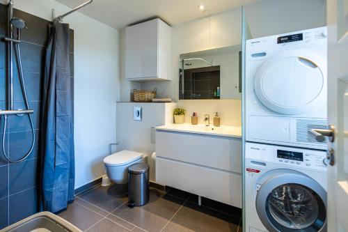 a small bathroom with a washer and dryer in it at CPH Guest Homes in Copenhagen