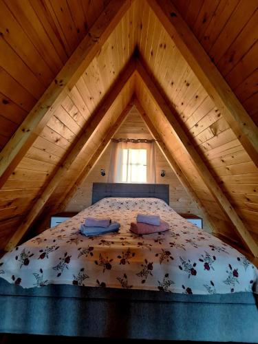 a bedroom with a bed in a wooden attic at Brvnara kao na dlanu 2 in Rudnik