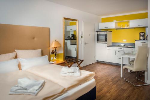 ein Hotelzimmer mit einem Bett und einer Küche in der Unterkunft Hanse-City-Boardinghouse in Greifswald