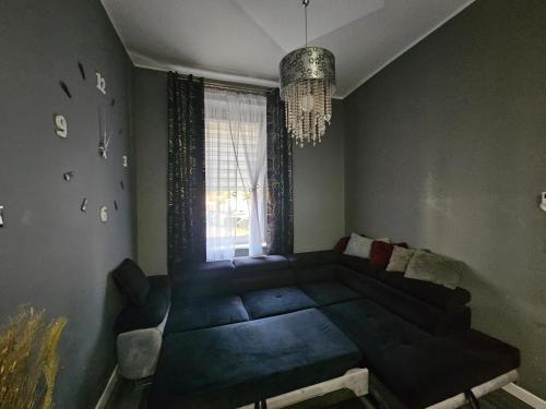 a living room with a blue couch and a window at Apartament DARIS in Wałbrzych