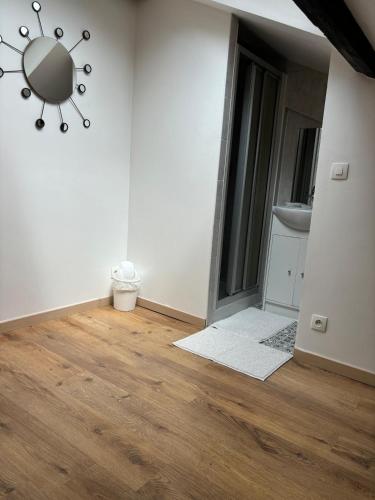 a room with white walls and wood floors and a chandelier at Studio climatisé in Paray-Vieille-Poste