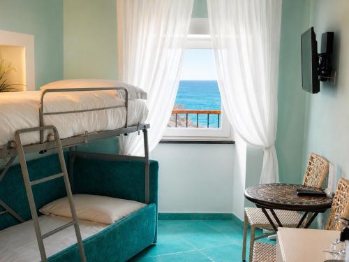 a bedroom with a bunk bed and a window with the ocean at La Polena Camere Vernazza - Suite vista mare in Vernazza