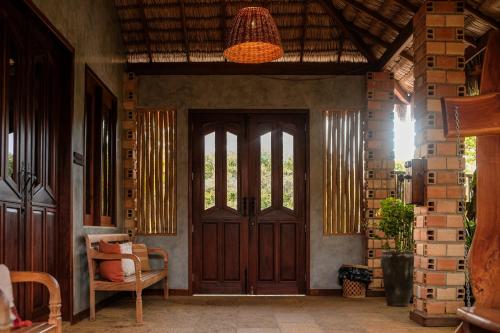 a room with a door and a chair and a lamp at Hotel Pousada Rancho das Dunas in Santo Amaro