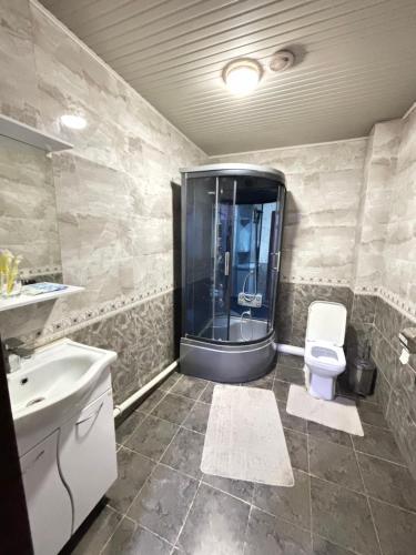 a bathroom with a shower and a toilet and a sink at Версаль отель in Türkistan