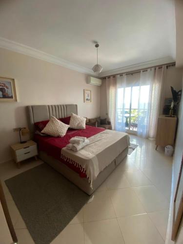 a bedroom with a large bed with a red blanket at Hanae malabata in Tangier