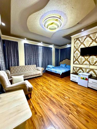 a living room with a couch and a bed at Версаль отель in Türkistan
