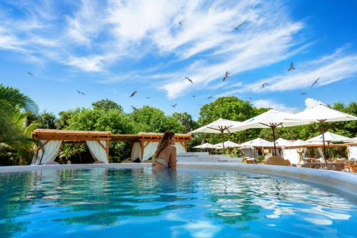 a woman standing in the water in a pool at a resort at Pao Pao Cartagena in Isla Grande