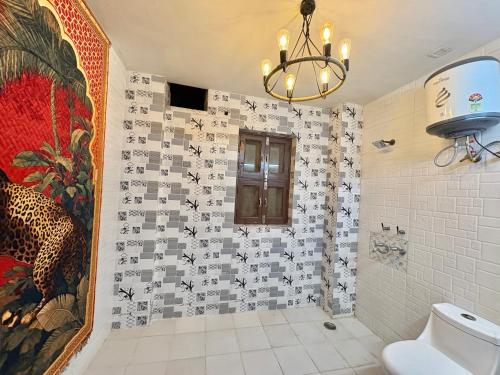 a bathroom with a chandelier and a tile wall at Moonlight Stays in Gurgaon