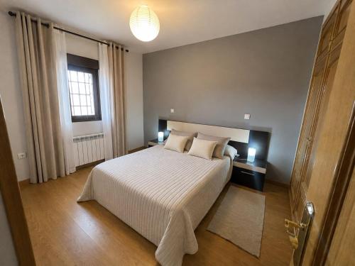 a bedroom with a large white bed and a window at El Mensario in Campisábalos