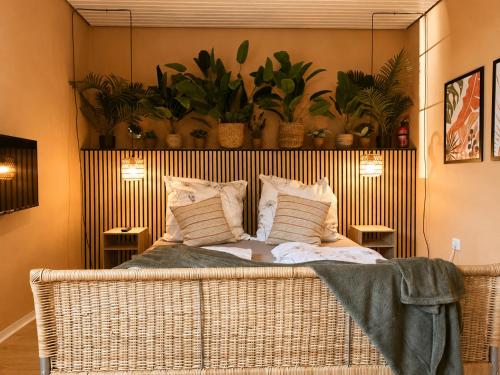 a wicker bed in a room with potted plants at Ruhiges & gemütliches Studio in Schneverdingen