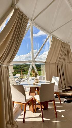 a room with a table and chairs and a large window at Natureza e luxo in Alagoa Nova